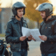 Jeune adulte présentant documents à un instructeur moto en extérieur